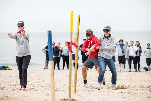 Energieke teamstrijd op het strand met volleybal, powerkiten en uitdagende spellen.