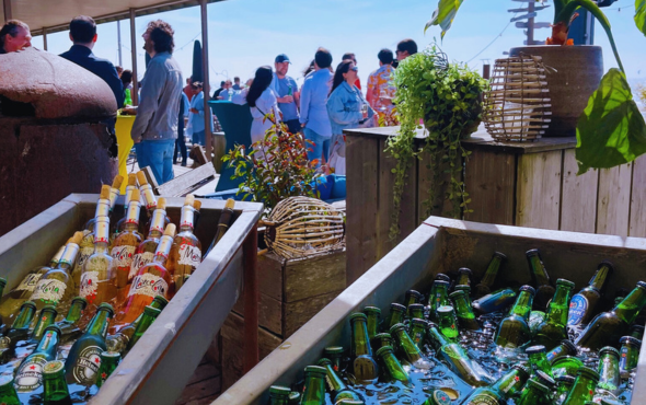 Bedrijfsfeest op het terras met koud bier, wijn en een ontspannen strandsfeer.